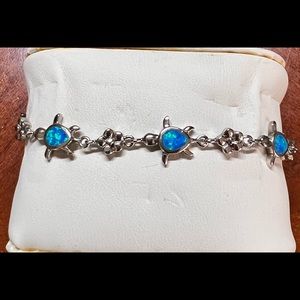 Sterling silver bracelet. The turtles have a blue /green stone